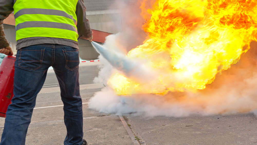 fire safety, image of man putting out fire wearing high vis