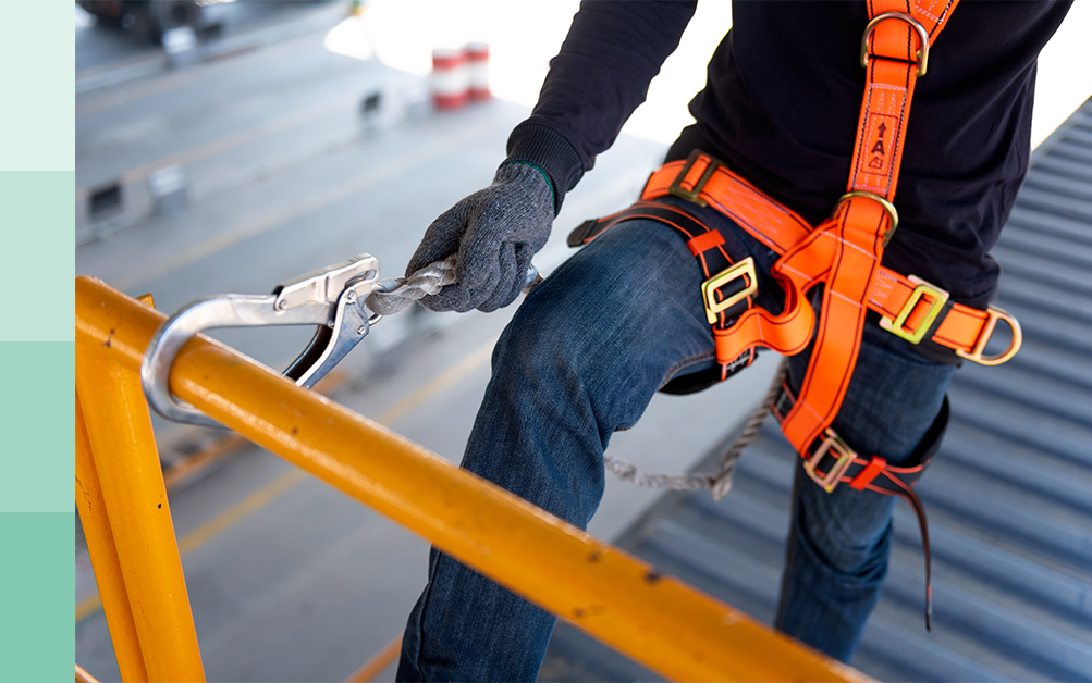 Dangers of construction - worker clipping belt for safety